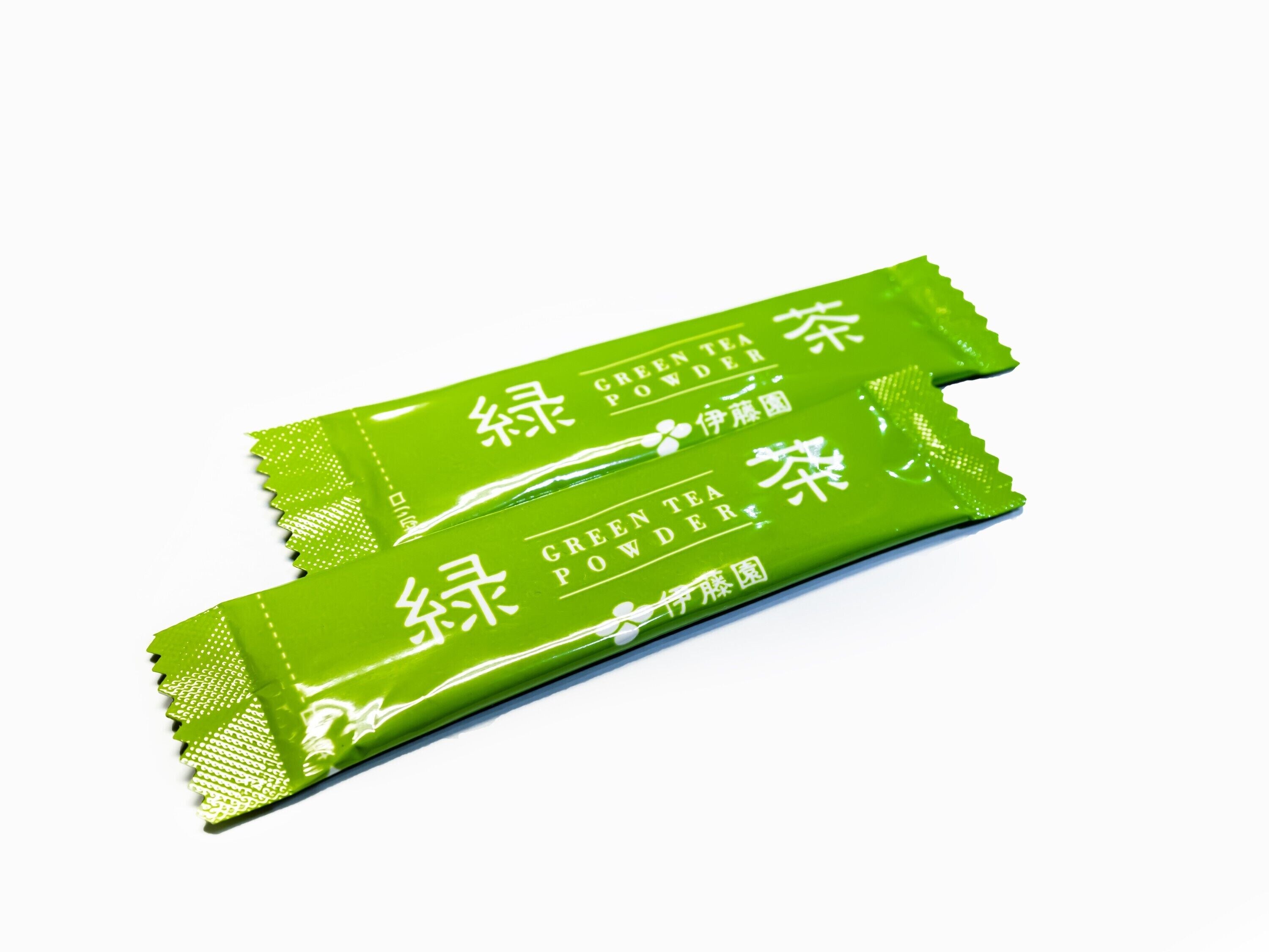 Two green packets of green tea powder.