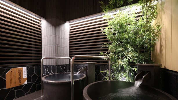 A traditional Japanese onsen with two hot tubs, bamboo plants, and wooden slats. - APA Hotel Ueno Ekimae (Tokyo)