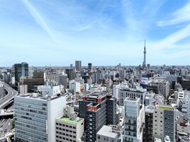 A cityscape with a prominent hotel labeled "APA HOTEL" and a tower in the distance.