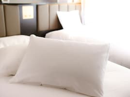 A bed with white bedding and a headboard.