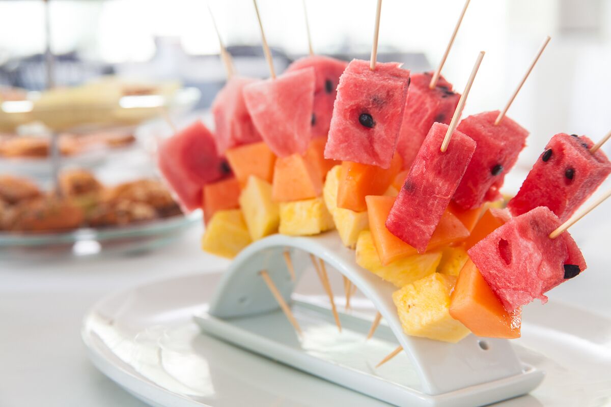 Ein Tablett mit Obstspießen, darunter Wassermelone und Cantaloupe.