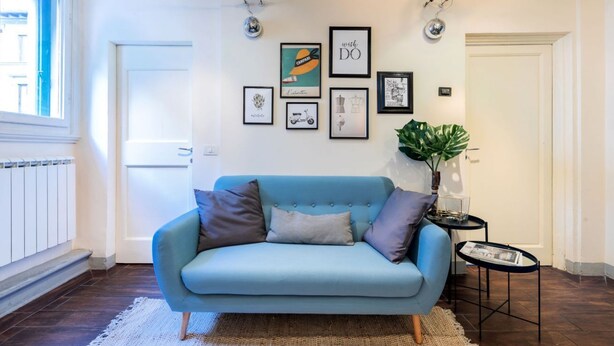 A room with a light blue sofa, a small side table, and a potted plant. - Historic center⭐ Minutes to attractions, Train and River (Firenze)