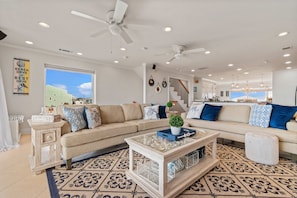 A spacious living room with a large sectional sofa, a coffee table, and a patterned rug. - Seabatical-Gulf Front Home with Private Beach Crossover, 3 King suites (Navarre)