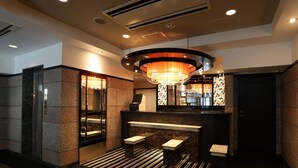 A modern lobby with a reception desk, a chandelier, and a glass elevator. - APA Hotel Chibachuo Ekimae (Chiba)