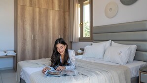 Une chambre à coucher comprenant un lit, une armoire en bois, une fenêtre avec des rideaux et un élément de décoration circulaire fixé au mur.