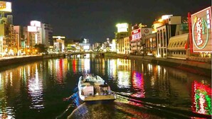 A nighttime river scene with a boat. - APA Hotel Hakata Ekimae 2chome (Fukuoka)