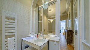 A bathroom with two sinks, a towel rack, and a large mirror.