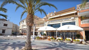 Een restaurant genaamd 'RESTAURANTE LA PENA' met terras en palmbomen.