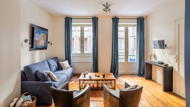 A cozy living room with a sofa, a coffee table, and a TV on a stand. - Le Traou Mad - Au cœur de l'Intra-muros (Saint-Malo)