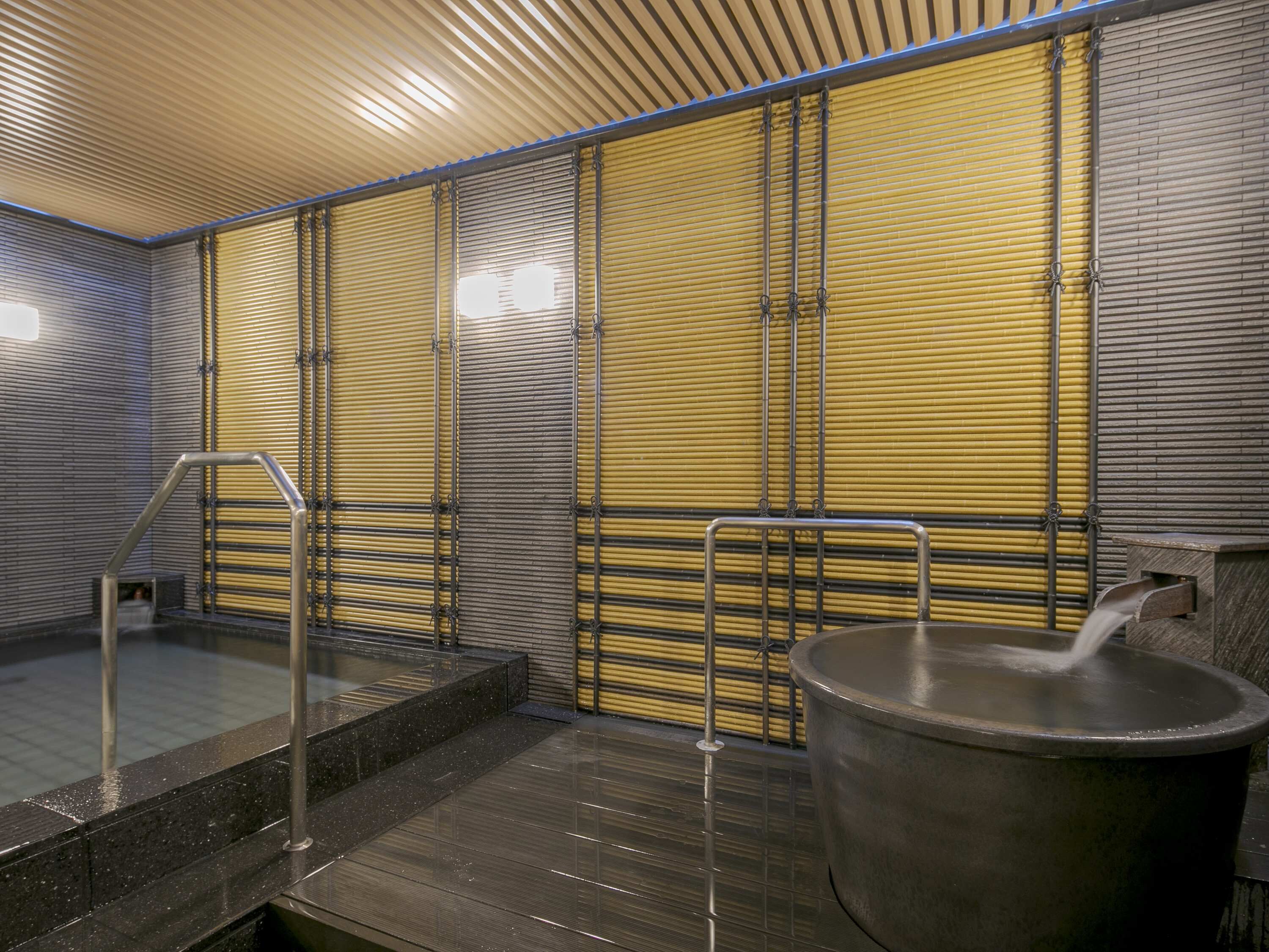 A modern bathroom with a large bathtub, a shower area, and a tiled floor.