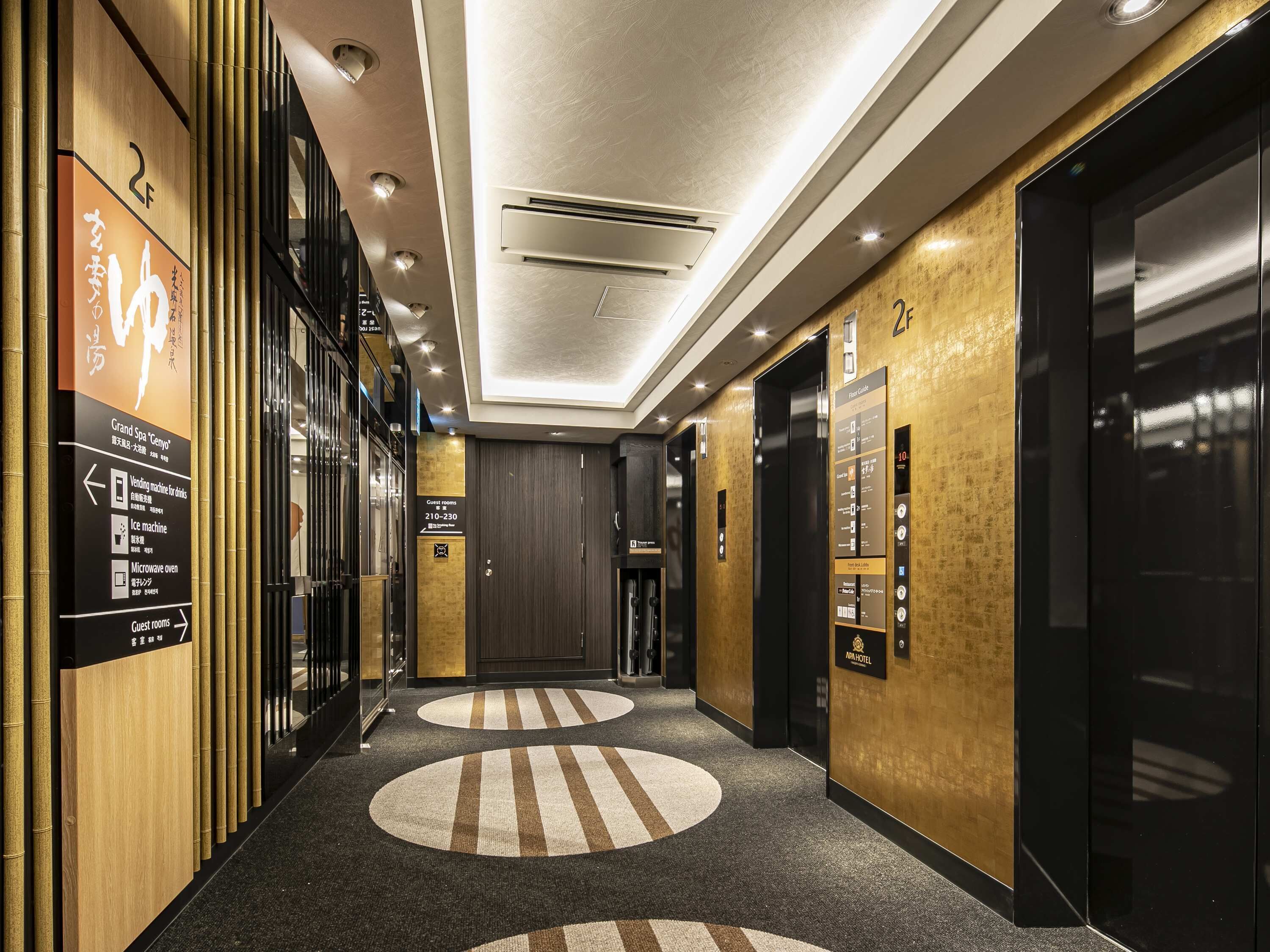 A hotel lobby with a modern design, including a vending machine, ice machine, and microwave oven.