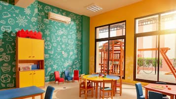 Ein Spielzimmer für Kinder mit bunten Wänden, einem Spieltisch und einem großen Fenster.