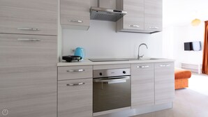 Een moderne keuken met een ingebouwde oven, een koffiezetapparaat en een spoelbak.