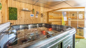 A wooden interior with a hot tub, wooden walls, and a 'ZEN' sign.