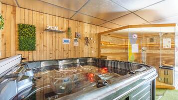 Een houten interieur met een hottub, houten wanden en een 'ZEN' bord.