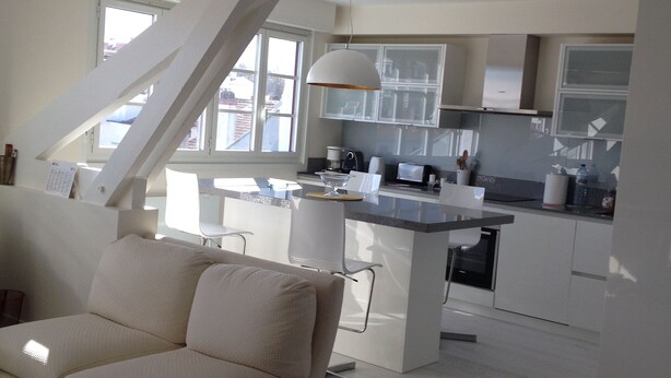 Un soggiorno moderno con un divano e una zona cucina sullo sfondo.