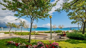 A park with benches, a lamppost, and a view of the sea.