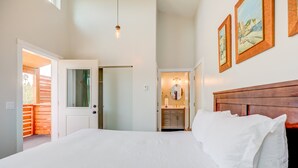 Un dormitorio con una cama grande, un cabecero de madera y vistas al balcón exterior.