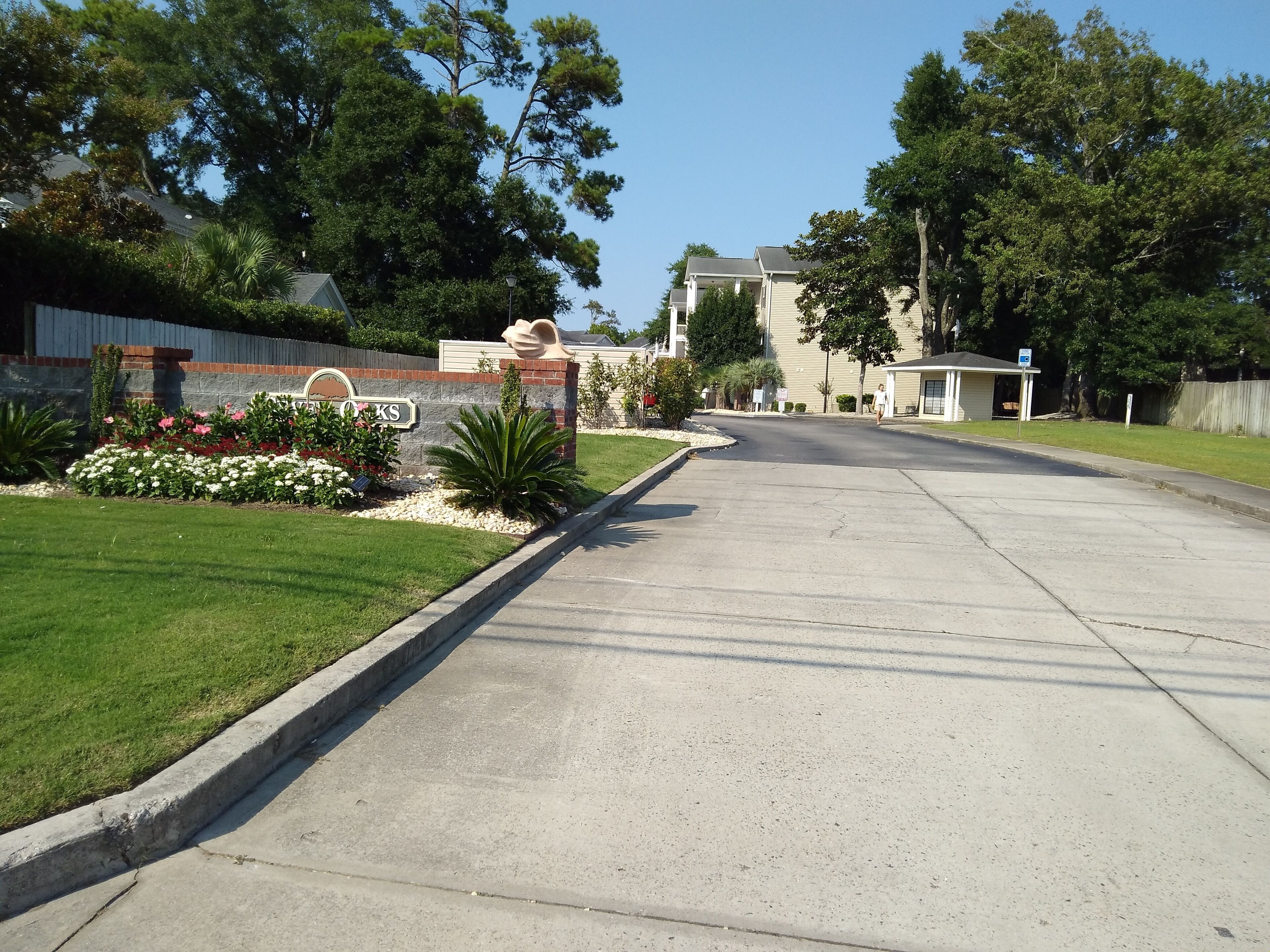 Un carrer residencial amb cases, un jardí ben cuidat i un cel serè.