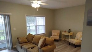 A living room with a beige sofa, two patterned armchairs, a small side table, and a ceiling fan. - Nice, totally re modeled, 3 bedroom condo in the heart of Cherry Grove Beach (North Myrtle Beach)