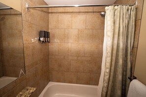 Ein Badezimmer mit Dusche, Badewanne und Handtuchhalter.