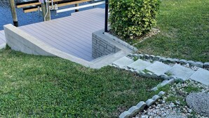 A marina with docked boats, a covered boat ramp, and a pathway leading to a grassy area with a small bush. - Love Water? Gulf Access, Boat Dock, Private Heated Pool in Lanai. (Cape Coral)