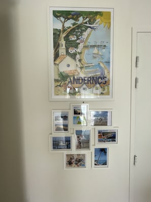 Een muur met een grote poster van Andernos en enkele kleinere ingelijste foto's.