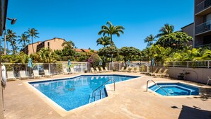 A pool area with two pools, lounge chairs, and palm trees. - Top Floor Ocean View & easy walk to the beach. Last minute booking 20 % discount (Kihei)