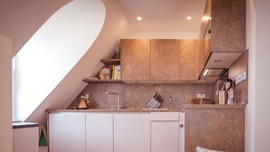 Eine kompakte Küche mit modernem Design, ausgestattet mit einem Kupferkessel, einer Spüle und einem Toaster.