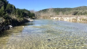 A clear river with visible rocks and vegetation on the banks. - 4 Maples on the Frio, Riverfront, Wi-Fi, @ Frio River Vacation Rentals (Concan)