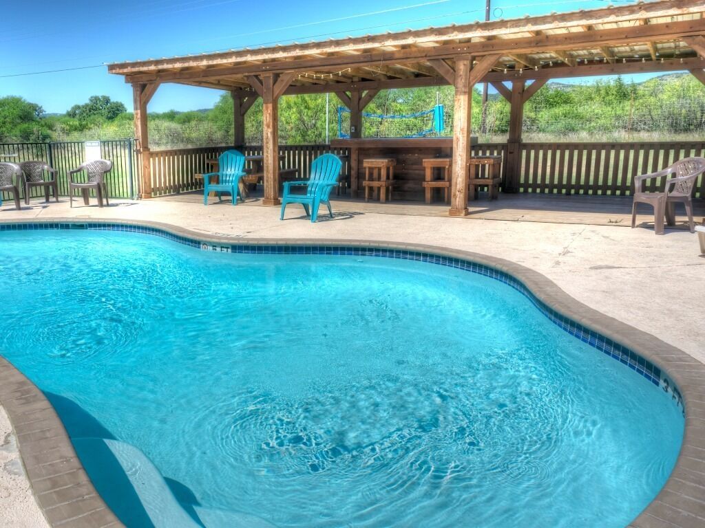 Una piscina con cubierta de madera y sillas.