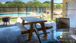 An outdoor patio with a pool, picnic table, and chairs. - Casa del Sol, Private Pool, Wi-Fi, @ Frio River Vacation Rentals (Concan)