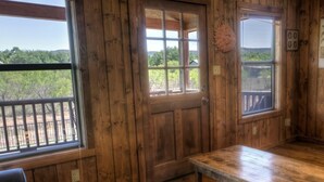 A wooden room with a large window, a door, and a bench. - Casa del Sol, Private Pool, Wi-Fi, @ Frio River Vacation Rentals (Concan)