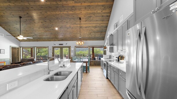 A modern kitchen with a large island, stainless steel appliances, and a wooden ceiling. - Celebration Station, Private Pool, Wi-Fi, @ Frio River Vacation Rentals (Concan)
