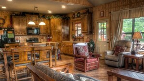 L’intérieur d’un chalet rustique, avec des meubles en bois, un coin repas et un espace salon confortable.