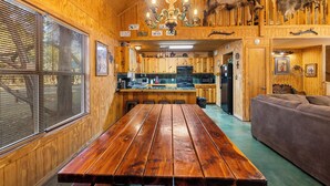 Een houten interieur met een eettafel, keuken en een bank.