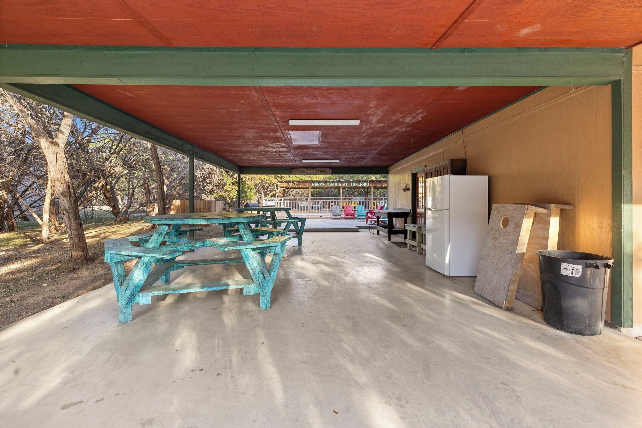 Un espace pique-nique abrité, équipé de tables de pique-nique et d’un réfrigérateur.