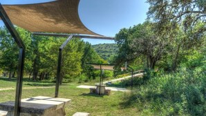 Un parque con mesas de picnic y una zona con sombra.