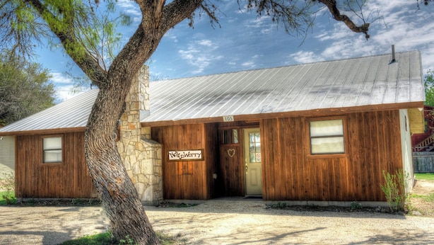 A rustic cabin with a stone foundation, wooden walls, and a metal roof. - Not To Worry, Wi-Fi, @ Frio River Vacation Rentals (Concan)
