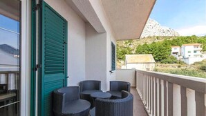 A balcony with wicker furniture and a green shutter door. - Apt w Jacuzzi, Balcony & sea View, 3 min to Beach (Dugi Rat)
