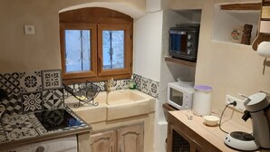 A compact kitchen with a washing machine, a sink, a microwave, and a coffee maker. - Charming village house (year-round rental) (Montmeyan)