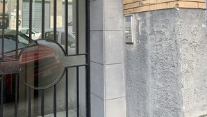 A building entrance with a glass door, a metal gate, and a brick wall. - Alleria Holiday Home (Salerno)