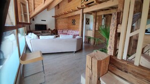 A cozy wooden interior with a sofa, a TV, and a dining area. - Le Typique Atypique Spacieux 140 m2 au Centre du Hameau de Perroix (talloires montmin)