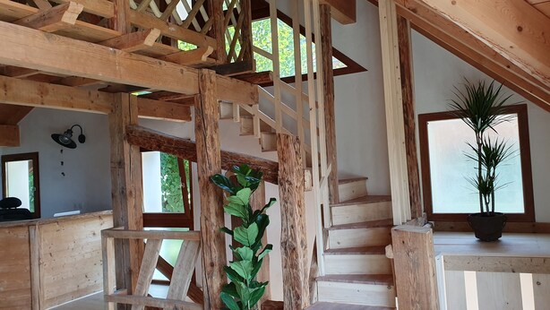 A wooden staircase with a lattice design, a potted plant, and a view of greenery outside. - Le Typique Atypique Spacieux 140 m2 au Centre du Hameau de Perroix (talloires montmin)