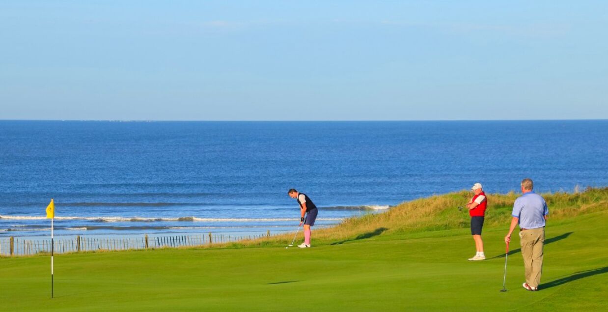 Um campo de golfe com vista para o oceano.