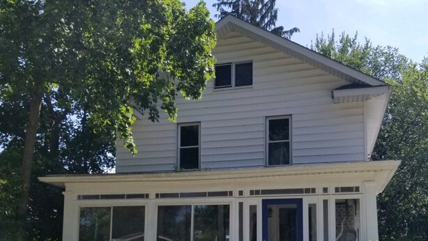 A two-story house with a front porch, a small front yard, and a picket fence. - Comfy Updated Historic Gem Pets OK 3B Vibrant Area (Painesville)