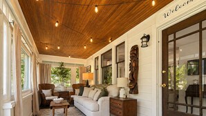 A cozy living room with a wooden ceiling, a sofa, a coffee table, and a lamp. - Comfy Updated Historic Gem Pets OK 3B Vibrant Area (Painesville)