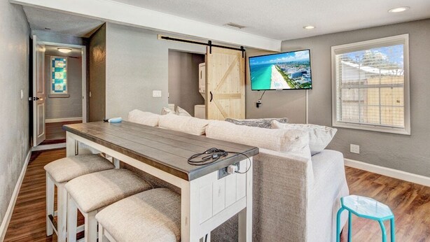 A compact living space with a kitchenette, a dining area, and a television mounted on the wall.