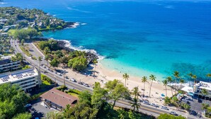 Une zone côtière comprenant une plage, une route et des bâtiments.