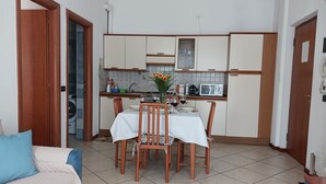 Eine kleine Küche mit Esstisch, Stühlen und einer Mikrowelle.